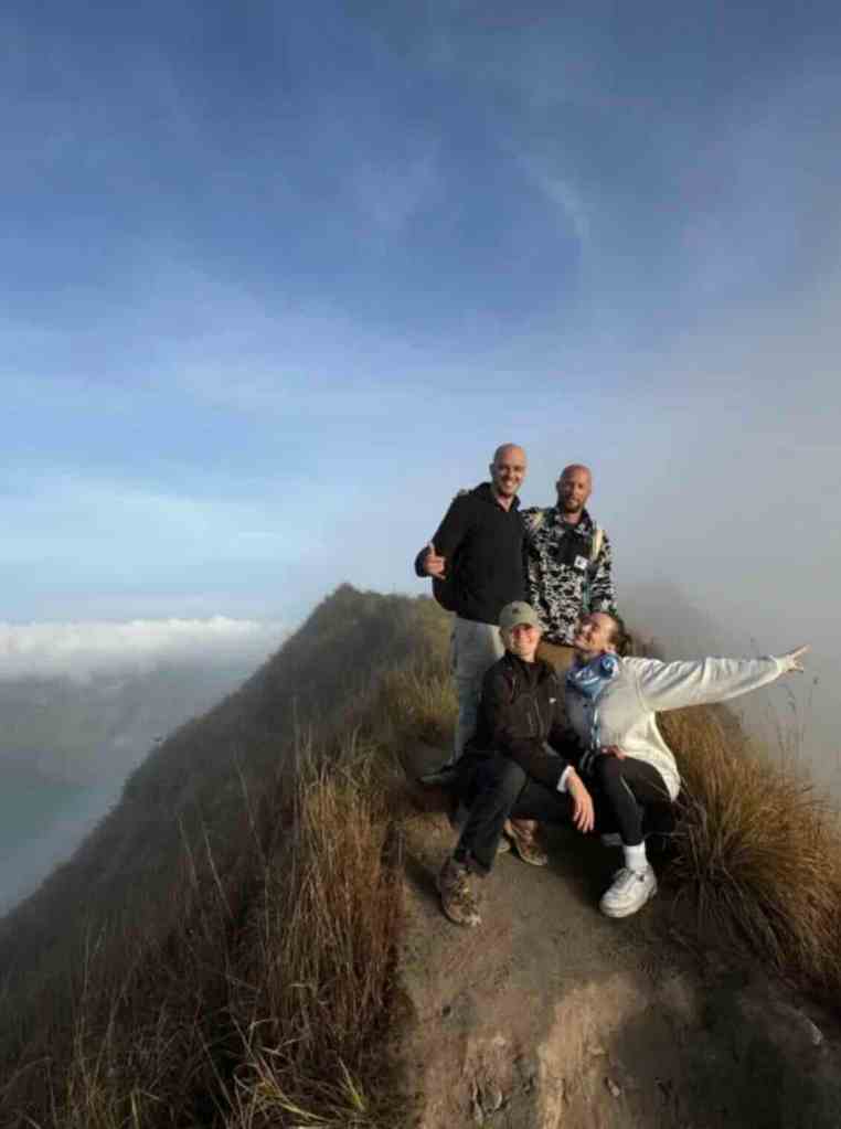 Travelers posing at the summit of Mount Batur after the sunrise hike