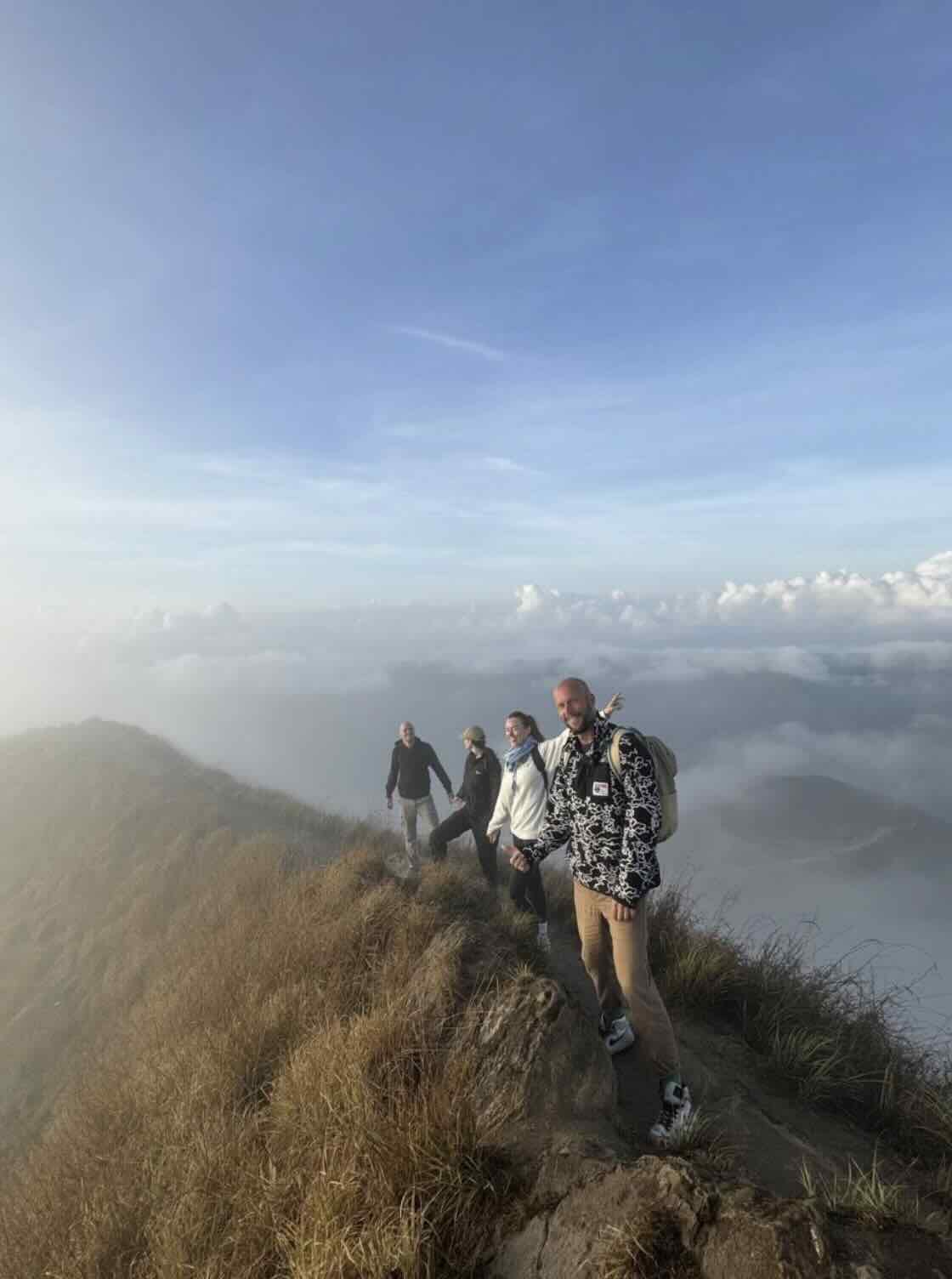 Hikers walking along the Mount Batur ridge after sunrise in Bali