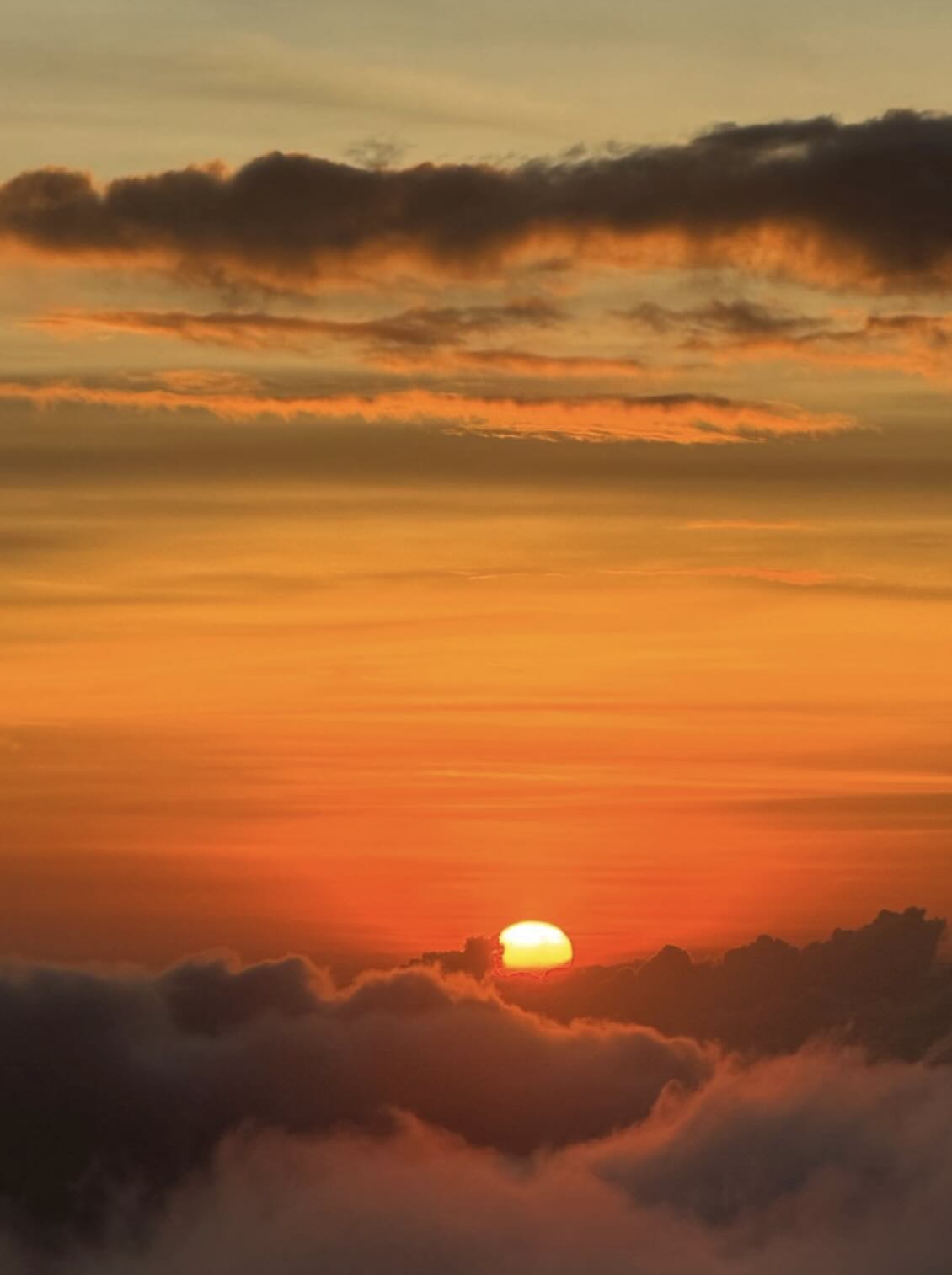 Orange sunrise above the clouds from Mount Batur volcano in Bali