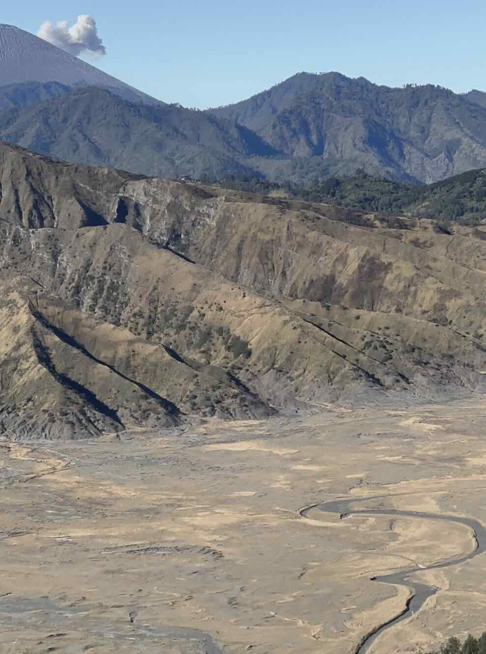 Wide view of the Mount Bromo caldera with Mount Semeru rising behind it