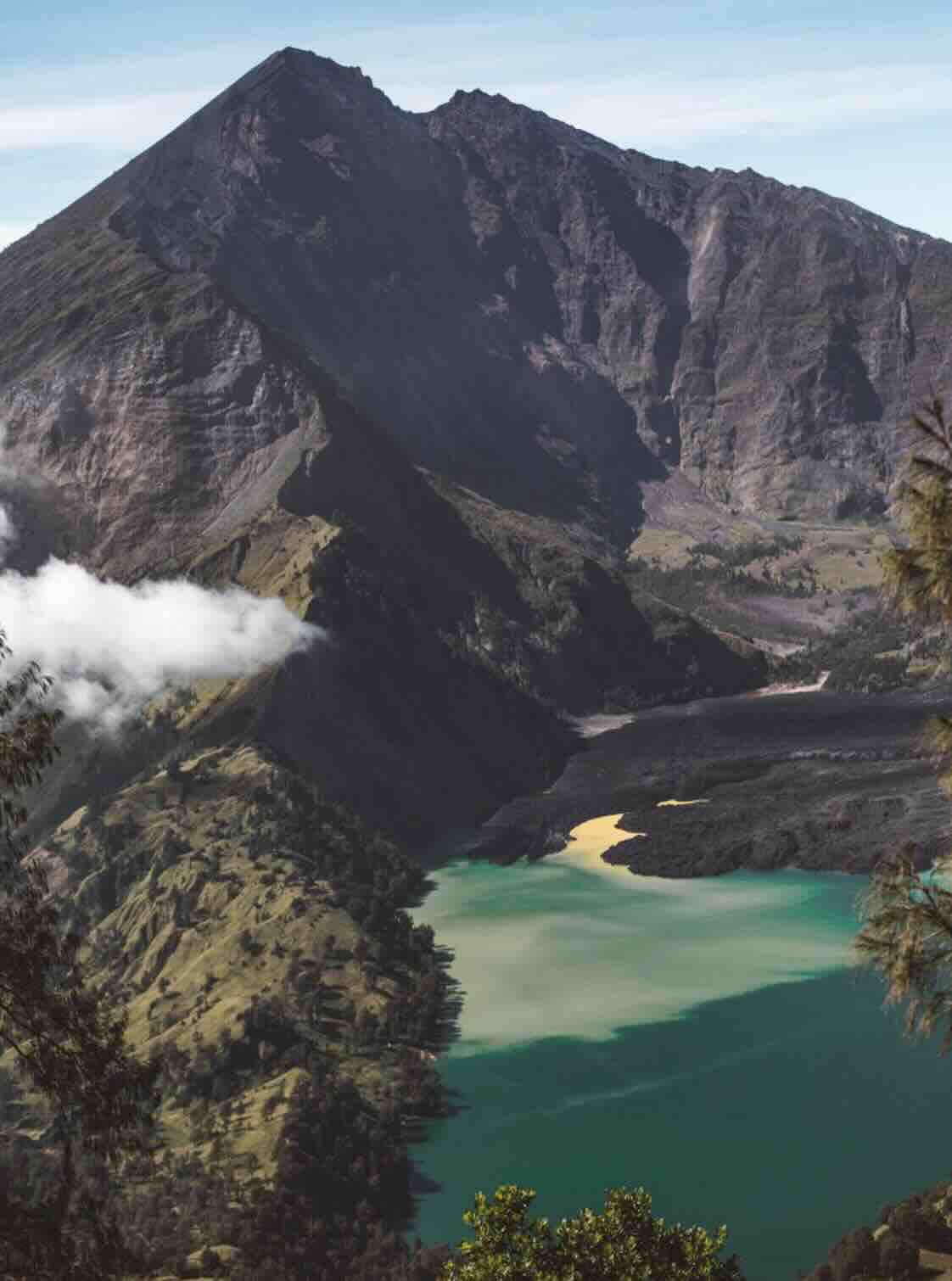 Green crater lake below Mount Rinjani during a volcano trek in Lombok