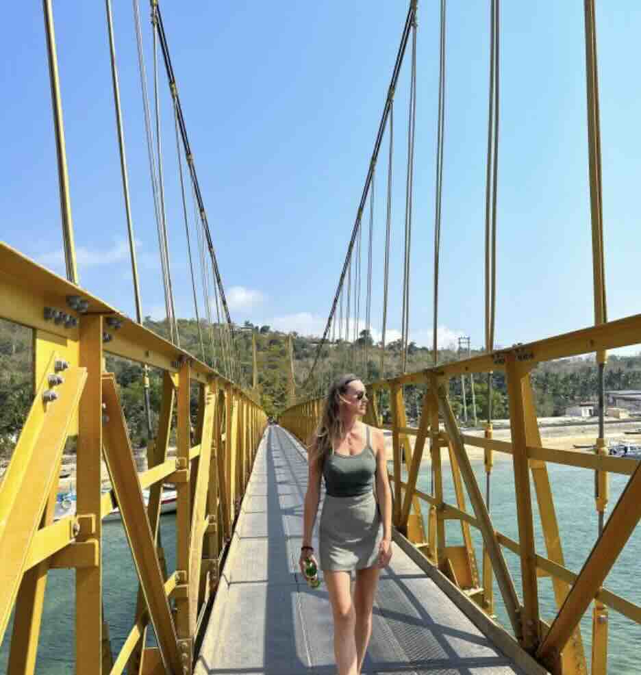 Traveler walking across the Yellow Bridge connecting Nusa Lembongan and Nusa Ceningan in Bali.