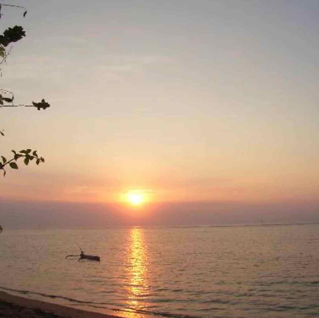 Golden sunrise over the calm ocean at Sanur Beach in Bali