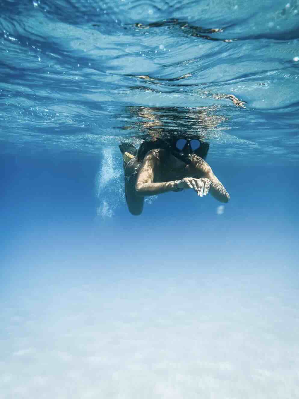 Snorkeler swimming in clear blue water at Blue Lagoon near Padang Bai, Bali