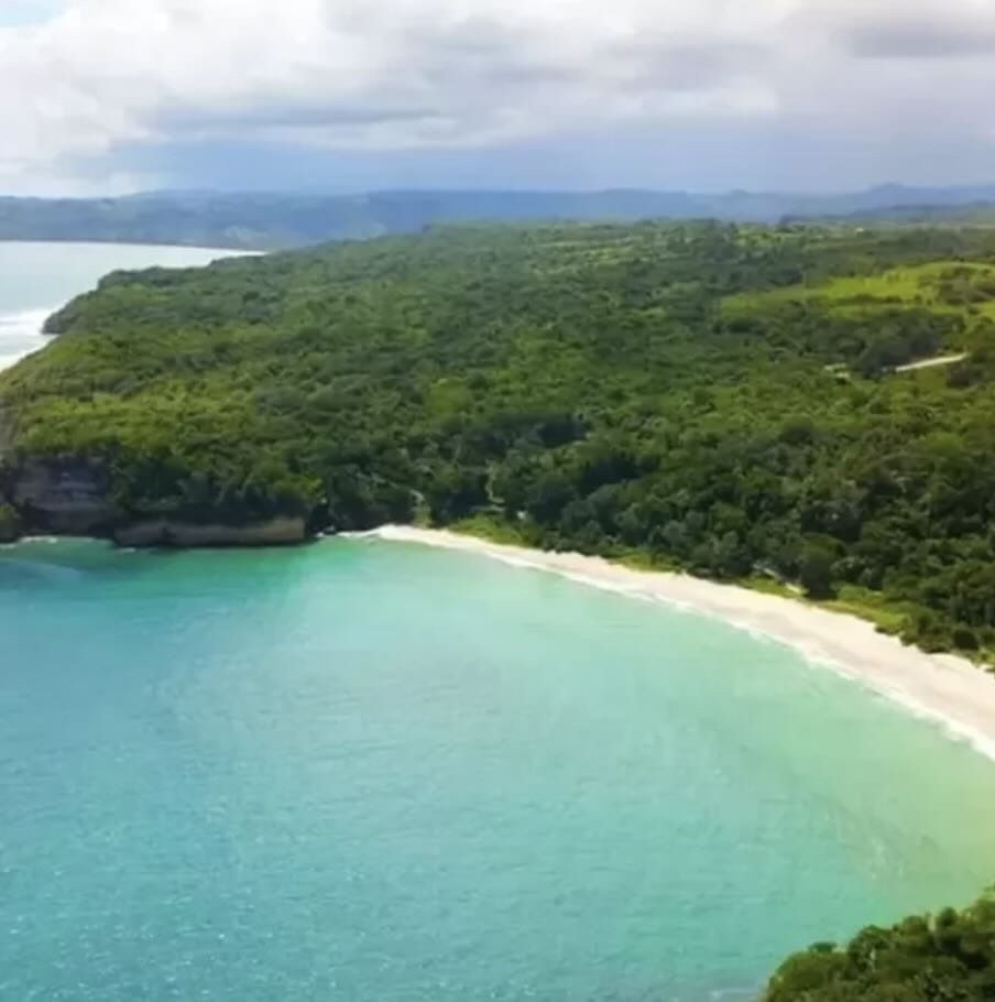 Lailiang Beach in West Sumba with turquoise water, white sand, and a quiet green coastline.