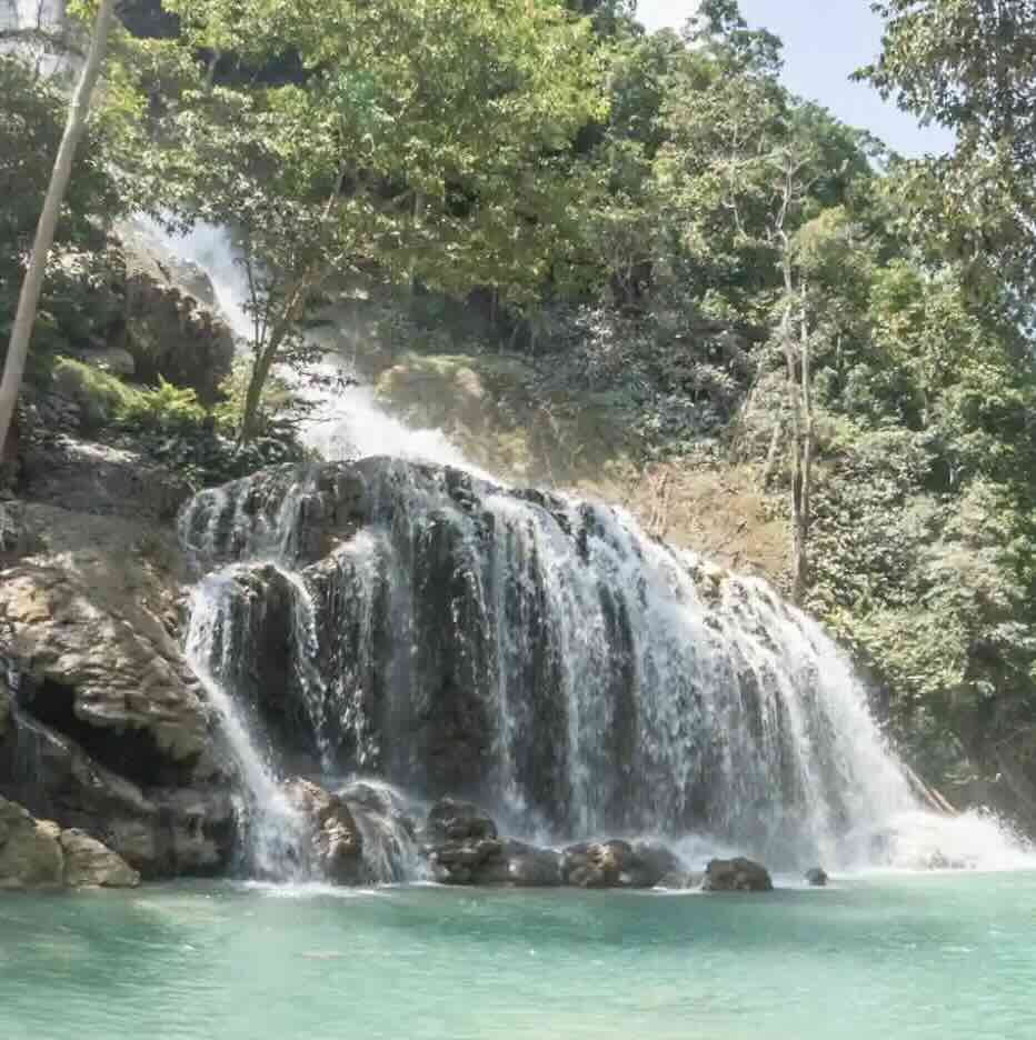 Lapopu Waterfall in West Sumba with cascading water, lush greenery, and a calm natural pool.