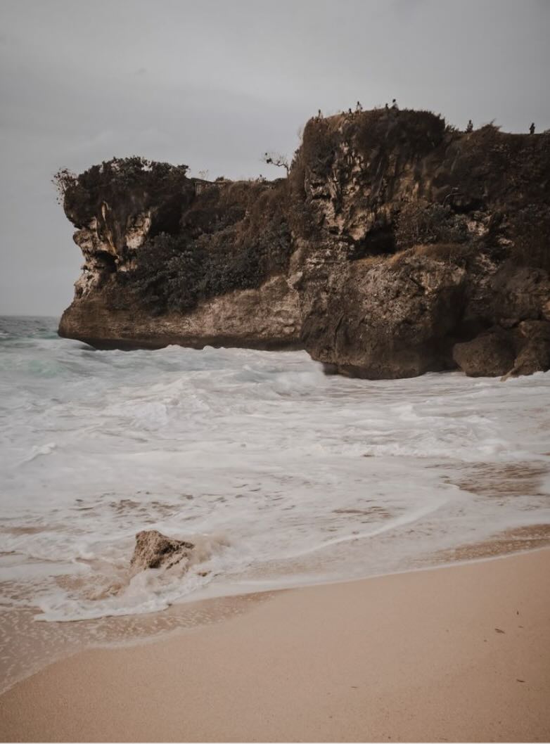 Rocky beach in North Sumba with crashing waves, dramatic cliffs, and a remote coastal atmosphere.