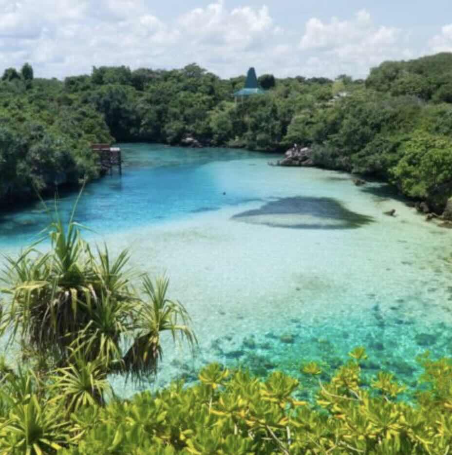 Weekuri Lagoon in West Sumba with clear blue saltwater, green cliffs, and a peaceful swimming area.
