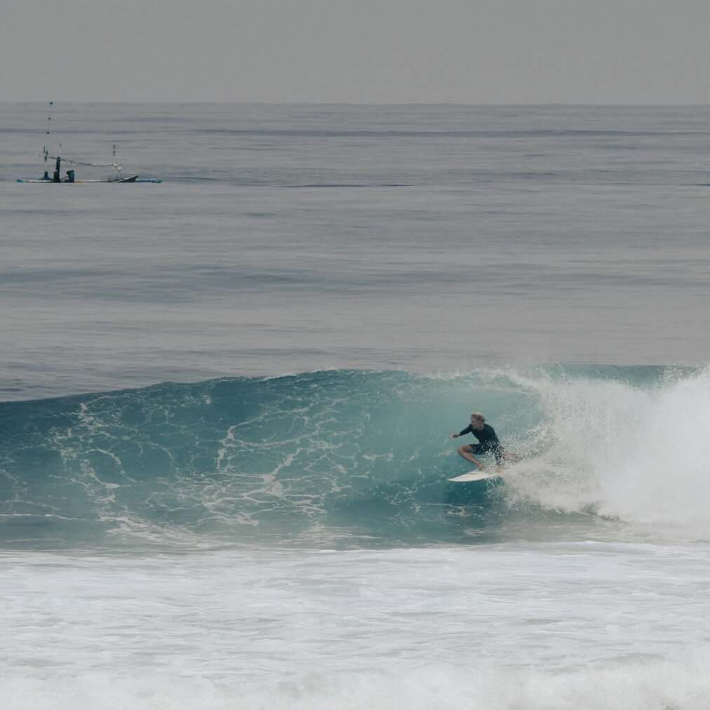 Surfer riding a wave at one of Uluwatu’s surf beaches in Bali