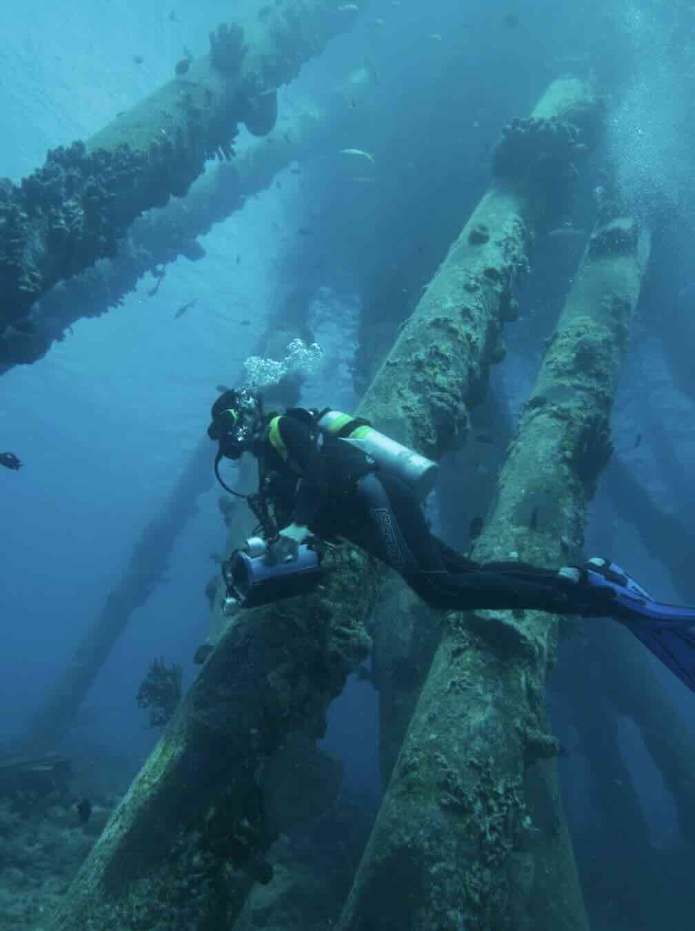 Scuba diver exploring the USAT Liberty shipwreck underwater in Tulamben, Bali
