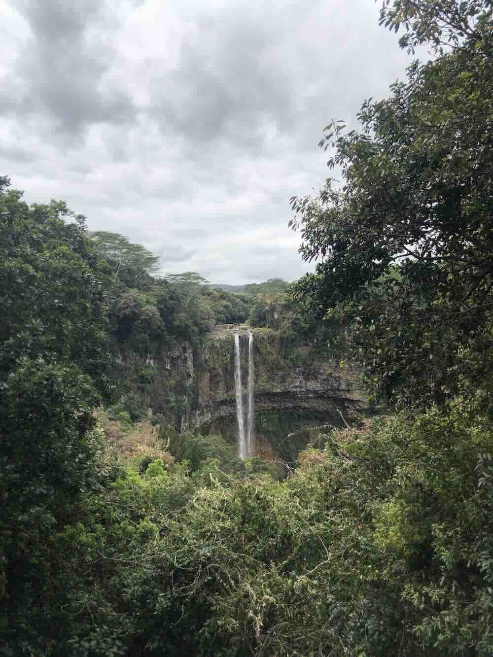 Scenic landscape view of Chamarel Waterfall cascading into a lush green valley in Mauritius.