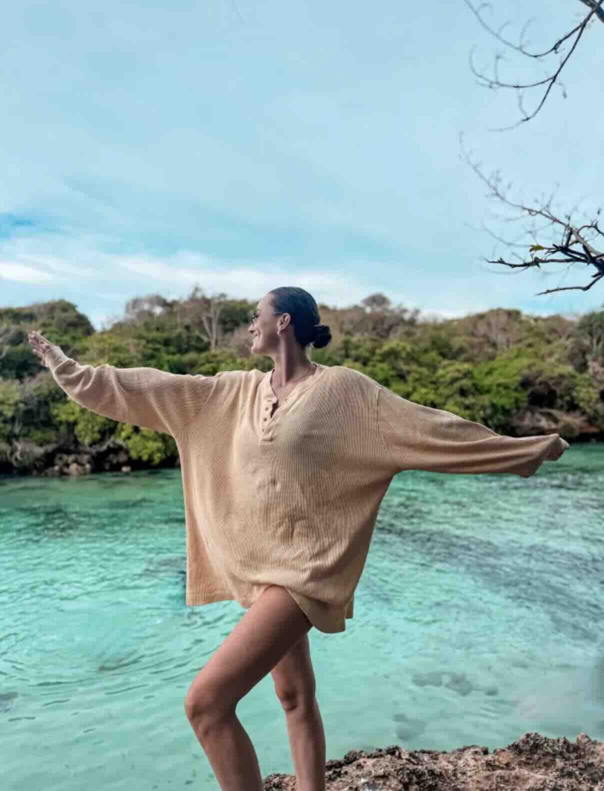 Traveler standing above the turquoise water at Weekuri Lagoon in Sumba