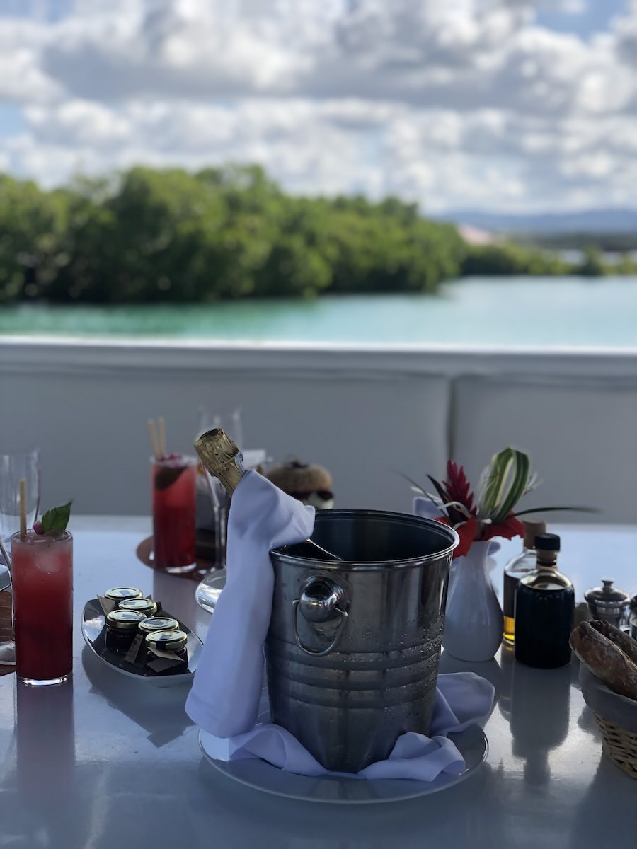 Drinks and a table setting aboard a luxury boat overlooking a mangrove lagoon in Mauritius.