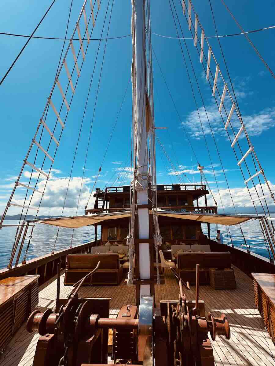 View along the main deck and tall rigging of a traditional Komodo Phinisi liveaboard.