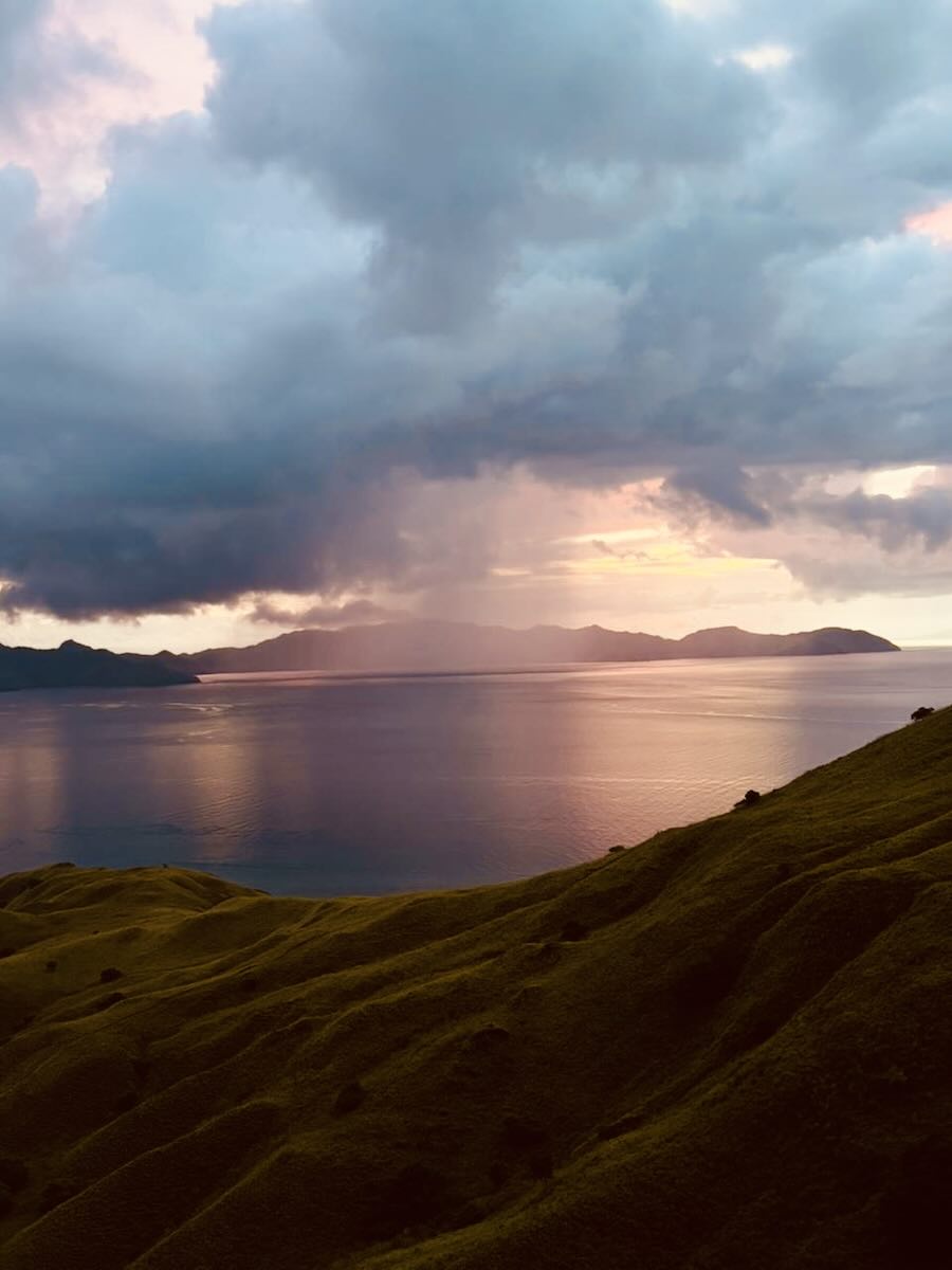Sunset over the sea and distant islands from Gili Lawa Darat in Komodo National Park.
