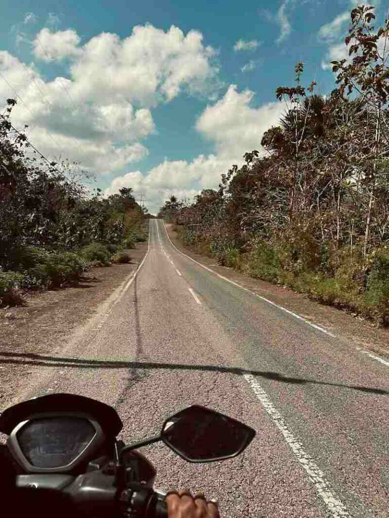 Riding a scooter along an empty road through Rote Island, Indonesia