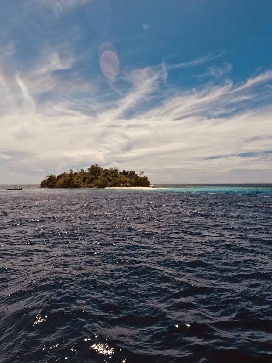 Small island and calm sea viewed from a liveaboard near Papanga during a Komodo charter.
