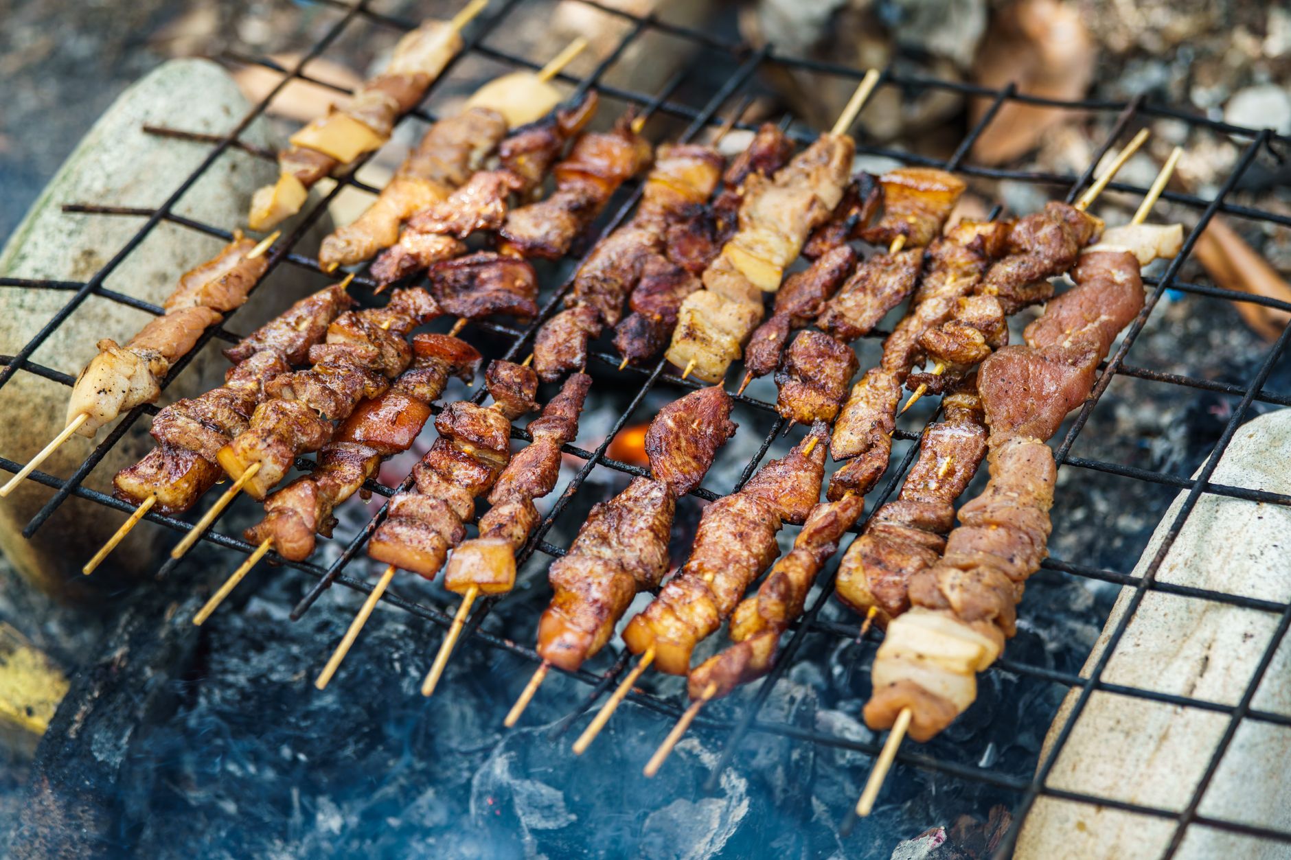 Indonesian sate skewers grilling over charcoal at a roadside stall in Mokdale, Rote Island