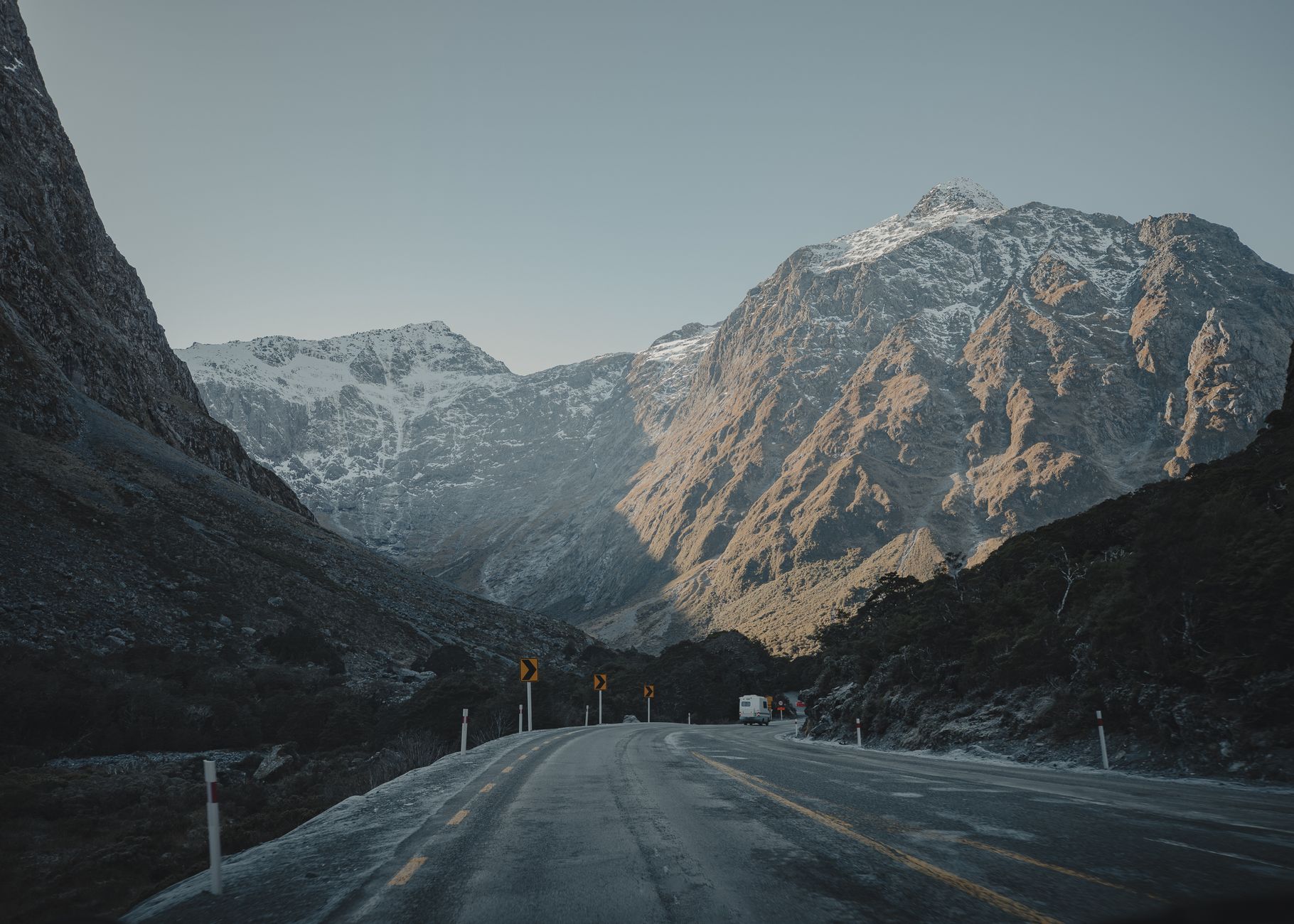 SH94 running beneath steep mountain peaks on the road toward Milford Sound in Fiordland.