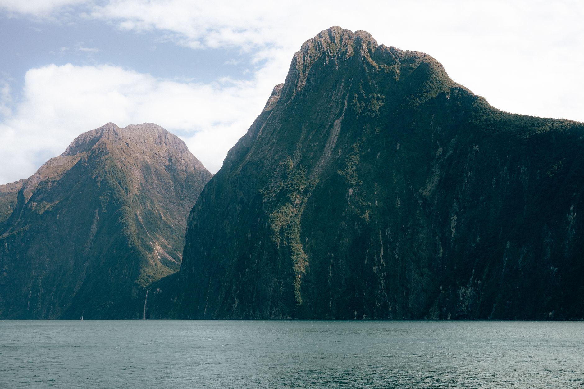 Steep mountain peaks rising from Milford Sound on New Zealand’s South Island.