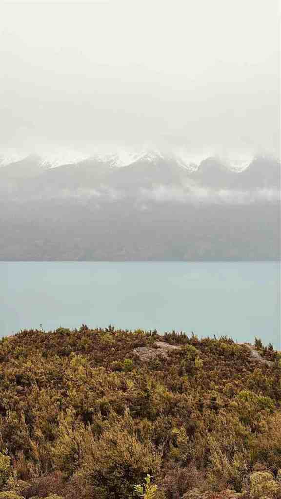A misty alpine lake surrounded by mountains during our September road trip through New Zealand’s South Island, where the weather could change incredibly quickly.