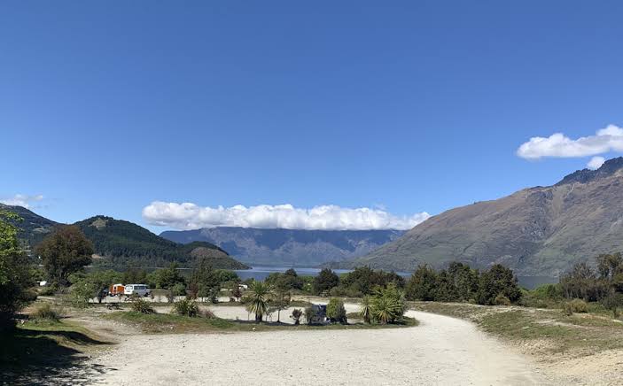 Scenic campervan campsite surrounded by mountains and open countryside on New Zealand’s South Island.
