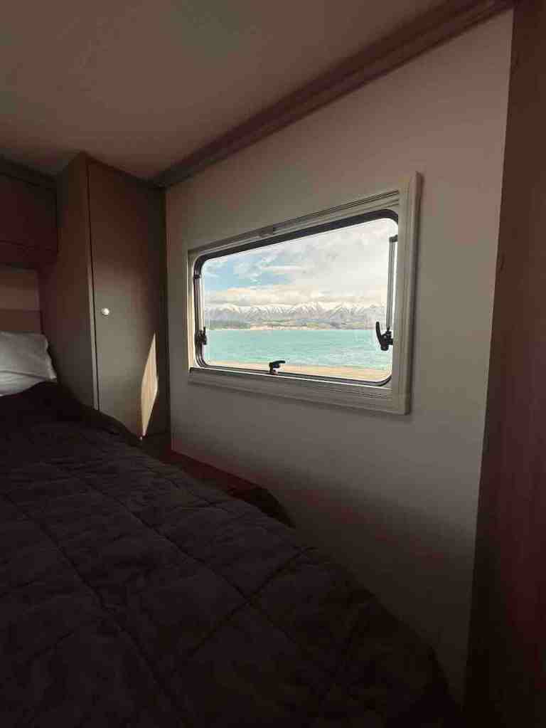 Mountain and lake views from the bed inside our Wilderness motorhome while travelling around New Zealand’s South Island.